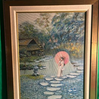 Sale Photo Thumbnail #44: Framed oil painting depicting a serene outdoor scene with a woman holding a pink parasol while standing on stepping stones near a wooded stream and a rustic hut in the background. The artist's signature is visible in the lower right corner. The wooden fra