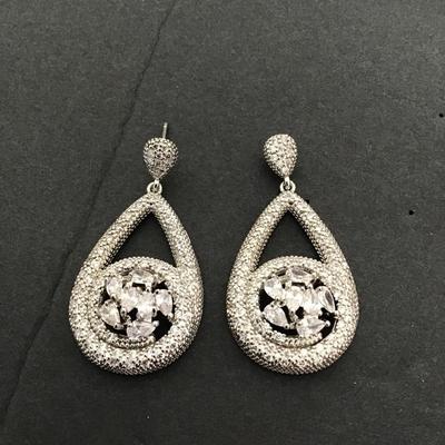 Silver toned dangle earrings with large clear, central stones in pave accent