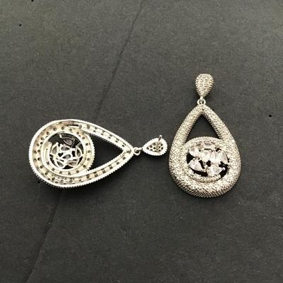 Silver toned dangle earrings with large clear, central stones in pave accent