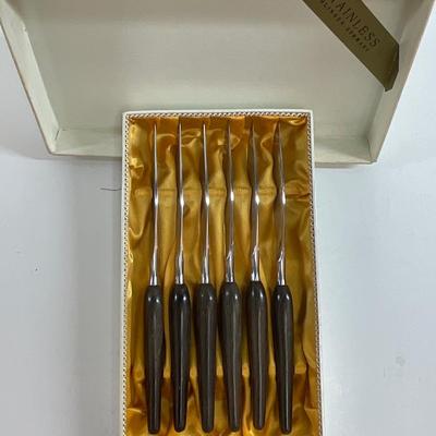 Sale Photo Thumbnail #176: Mid-Century Modern Style knives. Approx. 8.5" long, stainless steel blades and dark wood-grain handles. Satin-lined box.