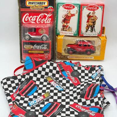 LOT 116: Coca Cola Collection: Matchbox Cars, Santa Playing Cards & NASCAR Fabric