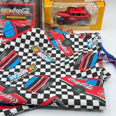 LOT 116: Coca Cola Collection: Matchbox Cars, Santa Playing Cards & NASCAR Fabric
