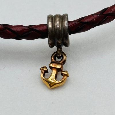 LOT 99; Pandora Leather Braided Bracelet, Blue Glass Floral Charm, Sterling Silver Smiling Budha Charm and a Dangling Anchor Charm