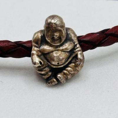 LOT 99; Pandora Leather Braided Bracelet, Blue Glass Floral Charm, Sterling Silver Smiling Budha Charm and a Dangling Anchor Charm