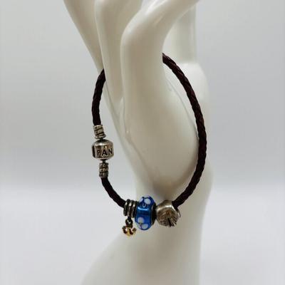 LOT 99; Pandora Leather Braided Bracelet, Blue Glass Floral Charm, Sterling Silver Smiling Budha Charm and a Dangling Anchor Charm