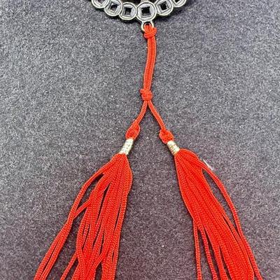 Sale Photo Thumbnail #379: Coin has an image of two monkeys facing each other.  Red cord with 2 tassels at the bottom.  Like new condition.