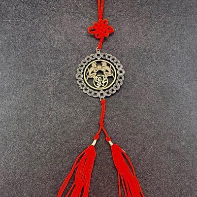 Sale Photo Thumbnail #378: Coin has an image of two monkeys facing each other.  Red cord with 2 tassels at the bottom.  Like new condition.