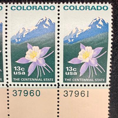Sale Photo Thumbnail #390: The stamps were issued by the USPS on May 21, 1977, in Denver, Colorado. They commemorate the centennial anniversary of Colorado becoming the 38th state of the Union in 1876. The design depicts the Rocky Mountains, the state flower (a white and lavender c