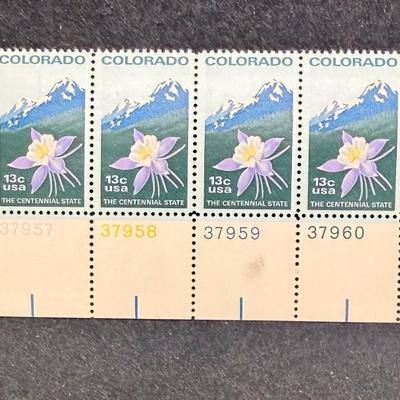 Sale Photo Thumbnail #389: The stamps were issued by the USPS on May 21, 1977, in Denver, Colorado. They commemorate the centennial anniversary of Colorado becoming the 38th state of the Union in 1876. The design depicts the Rocky Mountains, the state flower (a white and lavender c
