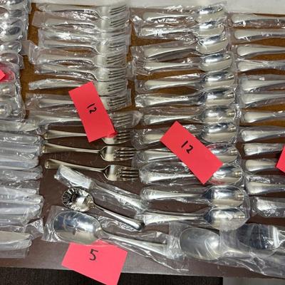 Sale Photo Thumbnail #93: In mostly unused condition and still in their packages. Qty: 5 Serving Pieces, 12 small forks, 12 big forks, 11 small spoons (missing 1) , 12 big spoons, land 12 knives.
