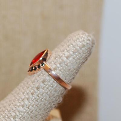 Size 6 Red Marquise Cut Stone Ring & 9 Black Accent Stones on a Gold Tone Band (3.0g)