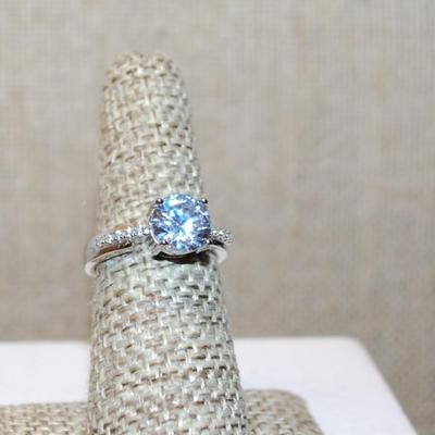 Size 6 Single Round Clear Stone Ring with Faint Line Accents on a Silver Tone Band (3.4g)