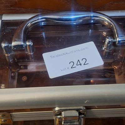 portable cosmetic makeup train case with a silver aluminum frame and rose gold/copper-toned clear panels.