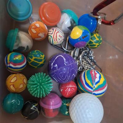 container of various balls and toys, one Hershey's base ball, several bouncy balls. Etc.