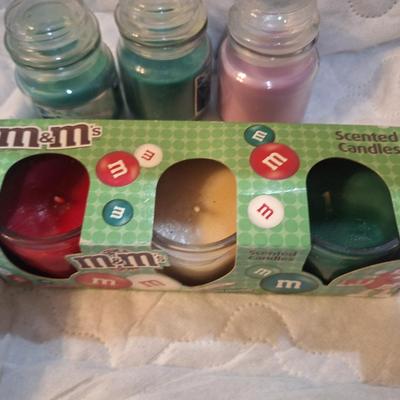 2 back of M&Ms scented candles and 3 small glass jar candles
