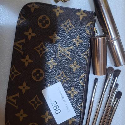 brown makeup bag with brushes and angel pin