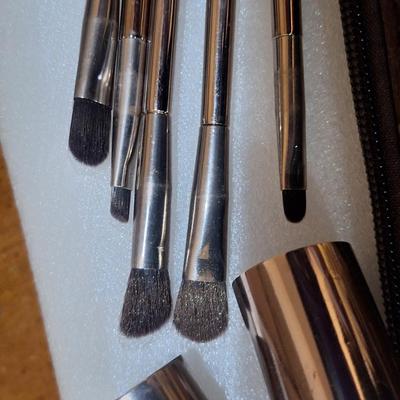 brown makeup bag with brushes and angel pin