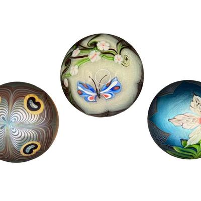 Sale Photo Thumbnail #58: Three pieces. One depicts a butterfly; one is iridescent with flower and feathers; and one is iridescent with pulled feathers. Measurement of largest: 3.5” Diameter. Pre-auction estimate: $300-$500. [MA]