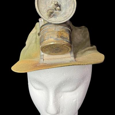 Sale Photo Thumbnail #65: This cap has the original “AutoLite” carbide lamp. The cap and lamp have age related wear. There is no glass lens on the lamp. Not tested. [KD]