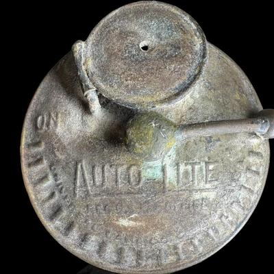 Sale Photo Thumbnail #68: This cap has the original “AutoLite” carbide lamp. The cap and lamp have age related wear. There is no glass lens on the lamp. Not tested. [KD]