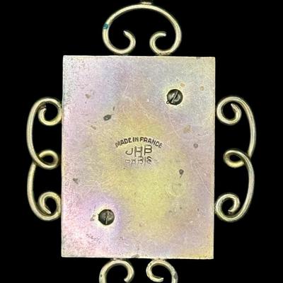 Sale Photo Thumbnail #83: This piece is marked “JHP,” for Jean Hippocampe Painleve’. It was made in France in the 1930s. It features a brass setting with a centerpiece made of Galalith (an early plastic), with two brass seahorses, surrounded by decorative metal scrollwork. M