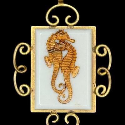 Sale Photo Thumbnail #82: This piece is marked “JHP,” for Jean Hippocampe Painleve’. It was made in France in the 1930s. It features a brass setting with a centerpiece made of Galalith (an early plastic), with two brass seahorses, surrounded by decorative metal scrollwork. M