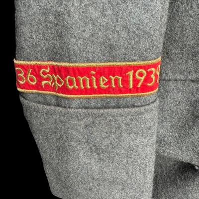 Sale Photo Thumbnail #173: This would have been worn by a General Officer. It is possibly a reproduction or prop. Made from wool, in a field grey color. The red piping on the cuffs aligns with an M36 model greatcoat. Possibly size XL. This has been in a smoky environment, and needs