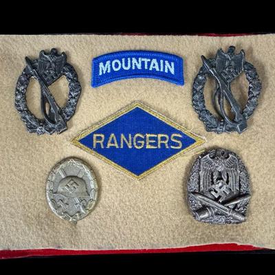 Sale Photo Thumbnail #183: Includes Mountain Division tab, Ranger patch, and four Nazi/Third Reich metal badges. Total of six pieces under glass. Age related wear. [JS]
