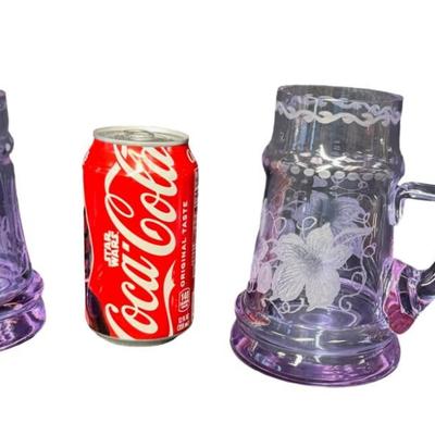 Sale Photo Thumbnail #286: Made in Czechoslovakia. Includes two purple etched beer mugs, and one amber delicate glass vase. Total of three pieces. One of the mugs has a chip on the rim (pictured). Measurement of tallest: 7”H. Pre-auction estimate: $75-$125. [RE]