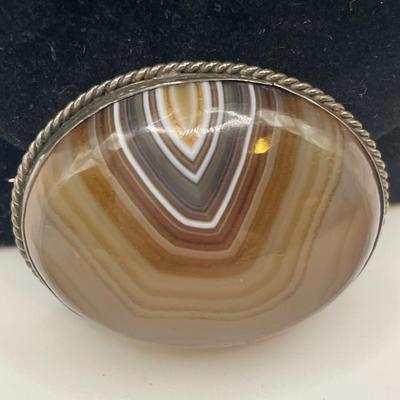 Victorian Scottish banded agate brooch with a polished oval-shaped stone set in a bezel setting