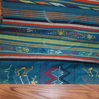 handwoven Guatemalan textile or tapestry, depicting human figures and animal motifs. 
