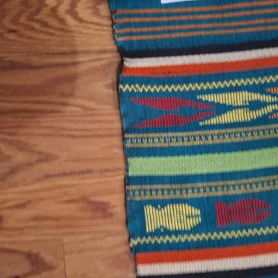 handwoven Guatemalan textile or tapestry, depicting human figures and animal motifs. 