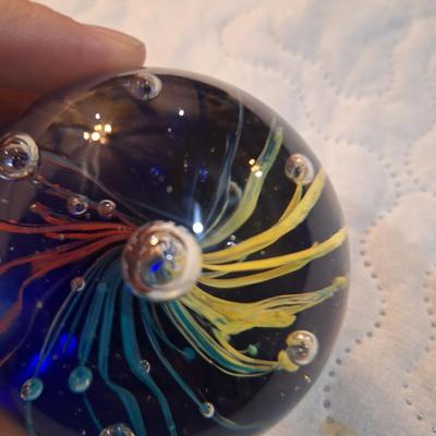 vintage hand-blown art glass paperweight, featuring a "firework" or "flower burst" design with controlled bubbles. 