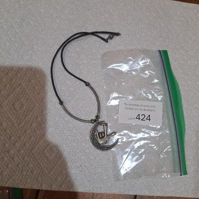 silver tone charm necklace with a pendant and hand making the I love you sign in American Sign Language.