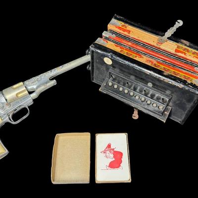 Sale Photo Thumbnail #347: Includes a wooden juvenile accordion, a vintage Colt .45 diecast cap gun, and a “Pigget” character card game. The bellows are intact on the accordion. All pieces have age related wear. Not tested. Measurement of accordion: 9”L (approximate). [SR]