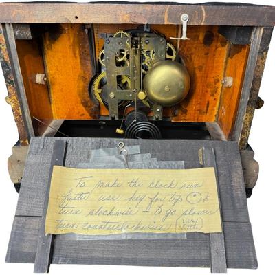 Sale Photo Thumbnail #376: This is black enameled on wood, and has a decorative brass bezel around ornamental pillars, or columns. Includes key. Age related wear. Not tested. Measurement: 15”W x 11”H x 6.5”D. [SR]