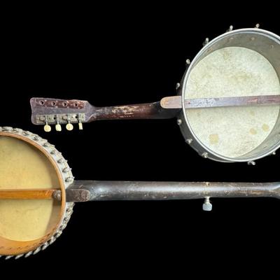 Sale Photo Thumbnail #392: Includes a mandolin banjo, and what is believed to be a 19th century J.H. Buckbee banjo. Both are nickel plated, open back banjos. Both need to be repaired. Measurement of largest: 35”L. [KD]