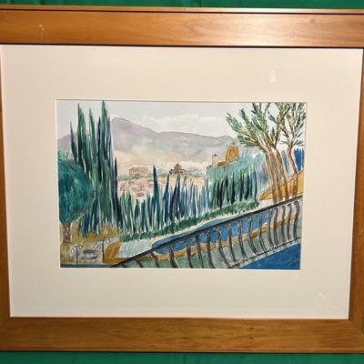 Sale Photo Thumbnail #66: A framed watercolor painting depicting a serene landscape with trees, rolling hills, and architectural elements in the background. The painting is set within a beige matte border and enclosed in a natural wood frame. The condition of the artwork and frame
