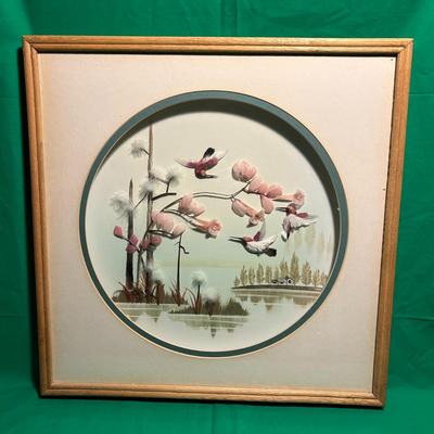 Sale Photo Thumbnail #68: A framed circular artwork depicting a tranquil nature scene featuring flying birds and blooming foliage. The piece is set within a square wooden frame with a beige mat border. The circular artwork showcases delicate, muted tones, emphasizing soft pinks an