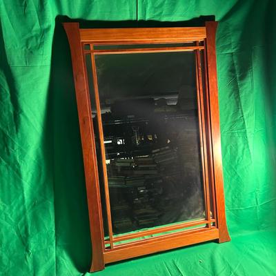 Sale Photo Thumbnail #79: Rectangular wall mirror featuring a rich wood frame with gently flared ends. The wood frame features decorative vertical and horizontal inlays that enhance its design. The mirror is in good condition, with no visible major damage to the glass or frame. Su