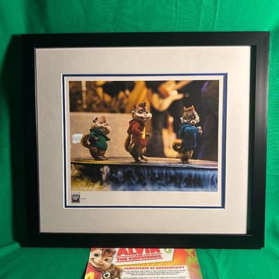 Sale Photo Thumbnail #91: Framed artwork featuring the animated characters Alvin, Simon, and Theodore from 'Alvin and the Chipmunks.' The piece comes matted in a black frame and includes a certificate of authenticity related to the series. A printed informational flyer is also inc
