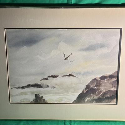 Sale Photo Thumbnail #94: Framed watercolor artwork depicting a serene landscape with birds flying above rocky formations and clouds. The piece is mounted within a double matte, and the frame features a metallic finish. Exact dimensions and artist details are not provided. Conditi