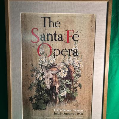 Sale Photo Thumbnail #97: Framed poster of The Santa Fe Opera for the 1990 season. Features an artistic floral design with text reading 'The Santa Fe Opera' and 'Thirty Second Season, July - August 1990.' Presented in a gold-tone frame with a white matted border. The poster and fr