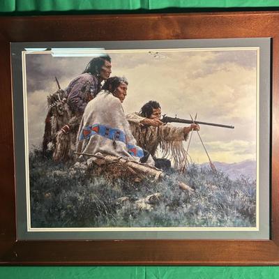 Sale Photo Thumbnail #103: Framed Western art print depicting three Native figures in a natural setting. One is aiming a rifle while two others look on. Includes a wooden frame with a matte border. The piece is set under glass and mounted securely, creating a striking presentation.