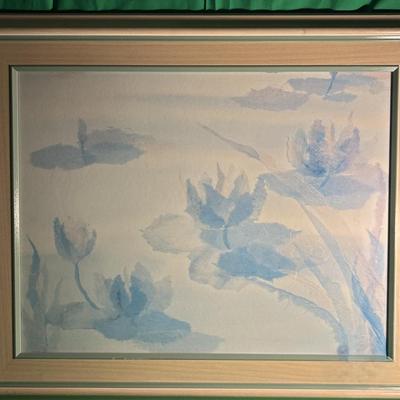 Sale Photo Thumbnail #113: Framed artwork featuring a watercolor depiction of water lilies in soft blue tones. The painting captures the serene essence of water lily blossoms and floating leaves. Set in a light wood frame with a linen mat and glass front. Condition appears consiste