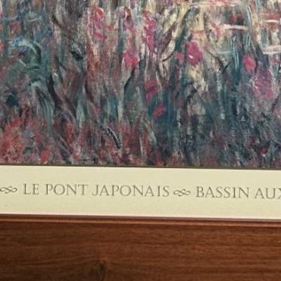 Sale Photo Thumbnail #127: Framed print of Claude Monet's "The Japanese Footbridge," featuring vibrant colors on a cream-colored mat with a wooden frame. The mat includes the printed title and artist's name below the artwork. Frame shows minor wear consistent with display. Exact di
