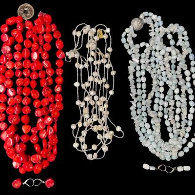Sale Photo Thumbnail #495: Includes a raw aquamarine necklace, a red coral necklace, and a pearl necklace. Two of the necklaces have matching earrings. [ES]