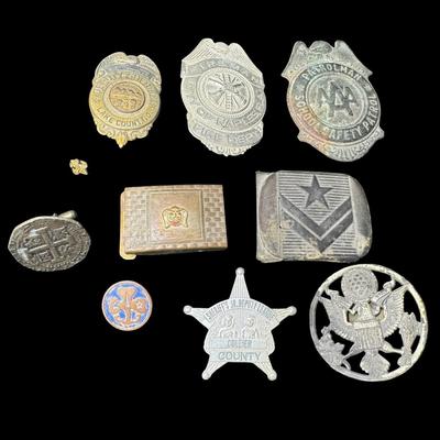 Sale Photo Thumbnail #511: Includes badges, belt buckles, and more. Total of nine pieces. Various metal compositions. Measurement of largest: 2.5”. [KD]