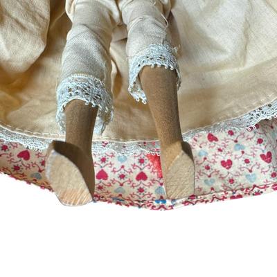 Sale Photo Thumbnail #537: This doll has a bisque head, and an articulating wooden body. It is believed to be made in Japan for U.S. import. The doll is wearing a Victorian style dress. The stand is included. Measurement of doll: 9.5”H. [JS]