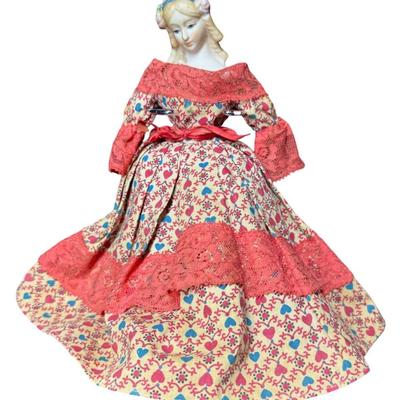 Sale Photo Thumbnail #534: This doll has a bisque head, and an articulating wooden body. It is believed to be made in Japan for U.S. import. The doll is wearing a Victorian style dress. The stand is included. Measurement of doll: 9.5”H. [JS]